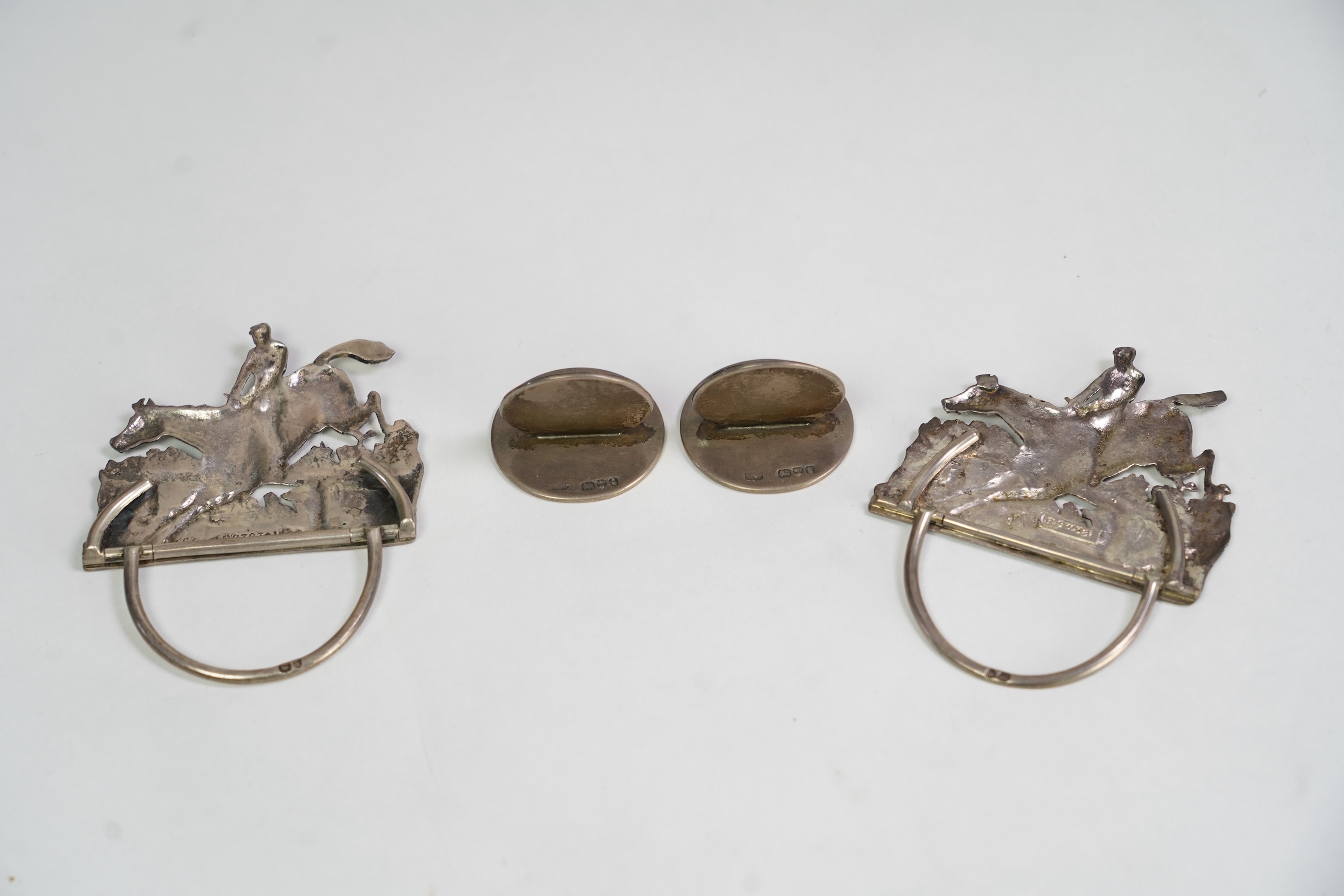 A pair of late Victorian silver menu holders, each modelled as a horse and rider leaping a fence, by Samuel Jacob, London 1894/5, height 66mm, together with a pair of Edwardian silver and enamel menu holders, each decora
